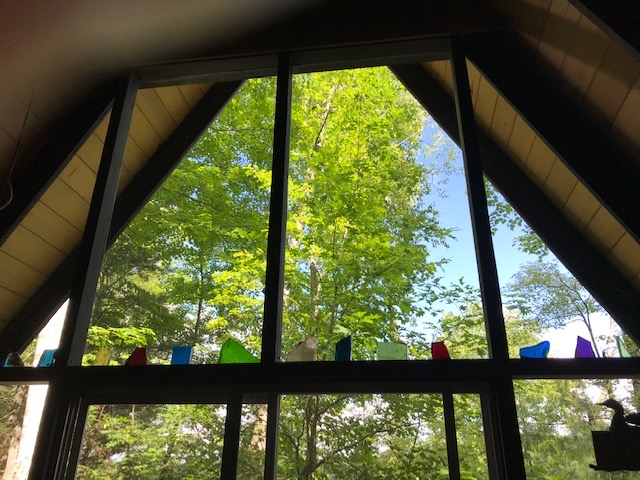 photo of an a-frame cottage with stain glass pieces in the window