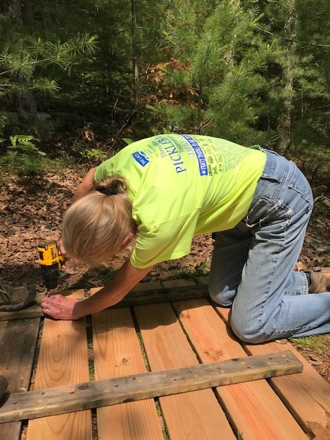 Woman drilling screw to secure pier boards together.