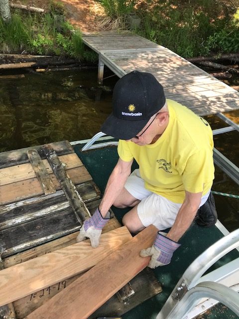 man arranging pier boards on pier