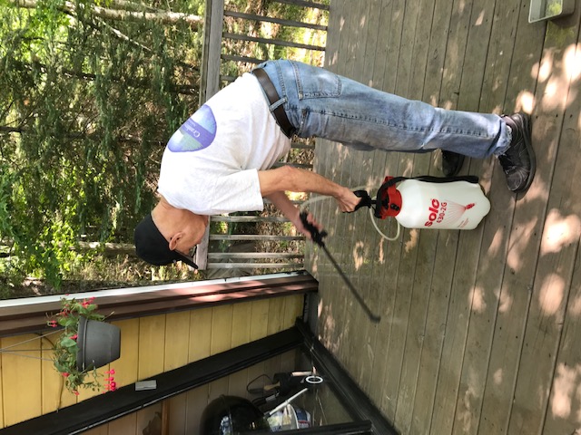 man using a pressure washer on deck