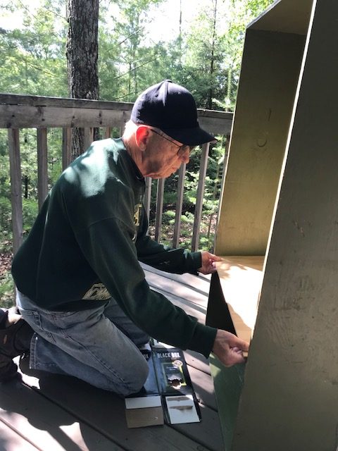 man putting in a shelve into the green box