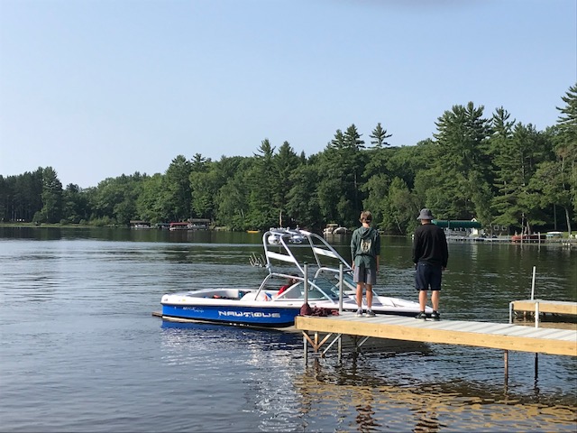 image of man and teenager waiting for speed boat at pier