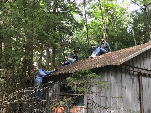 image of three men on the roof of a shed