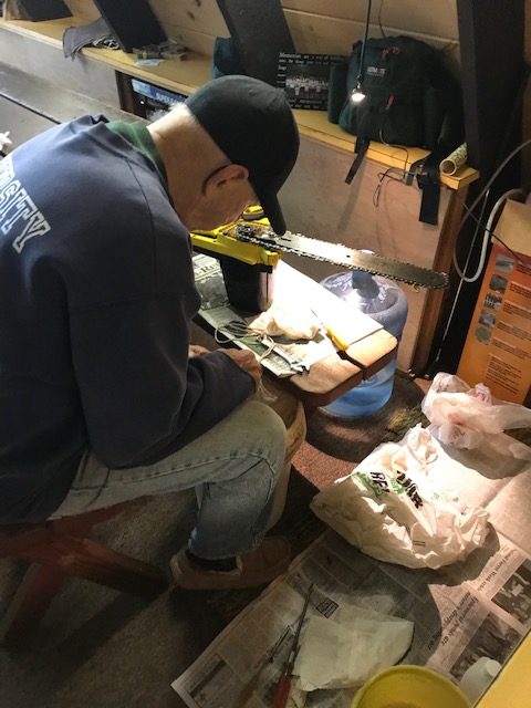 photo of man fixing chain saw