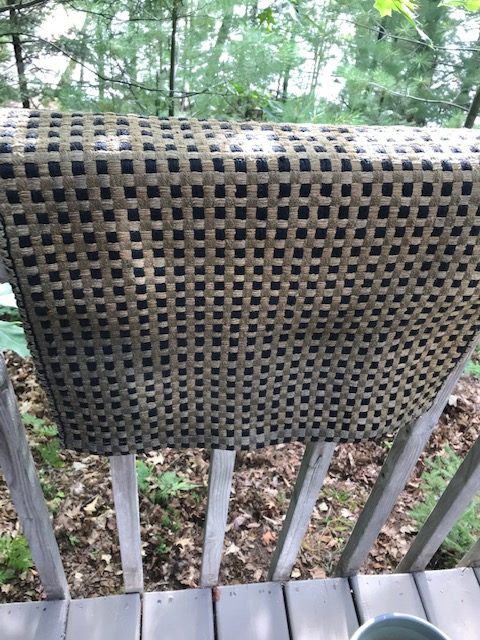 photo or small rug hanging over a porch railing.