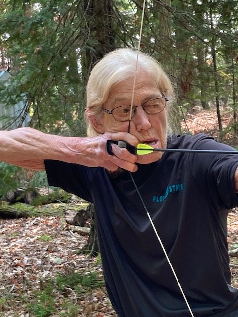 photo of woman shooting a bow and arrow