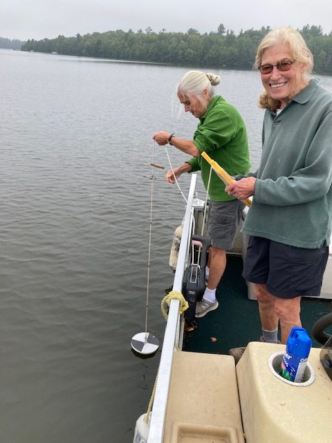 photo of two older women using a water clarity testing device.