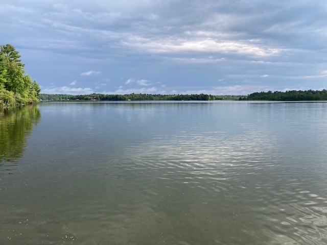 photo of calm lake and partly sunny skies.