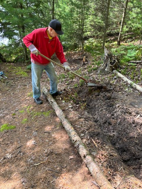 man digging small ditch for stair "log"