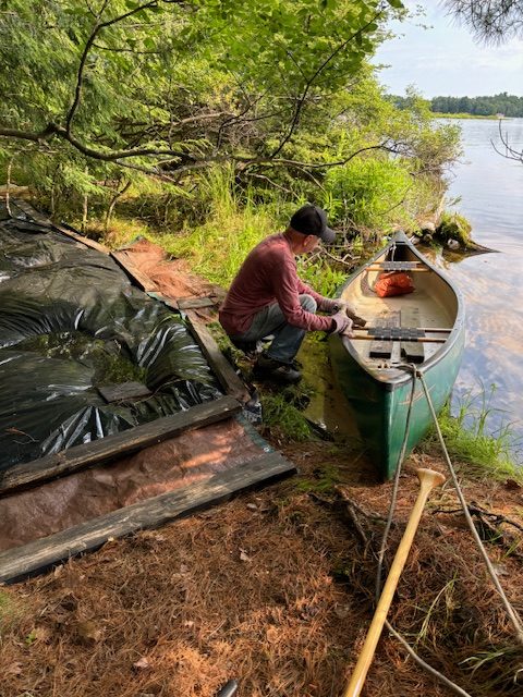 man preparing canoe for plants and tarps