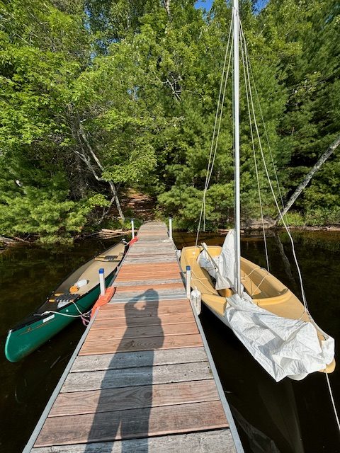 photo of dock with canoe on one side and sailboat on the other.