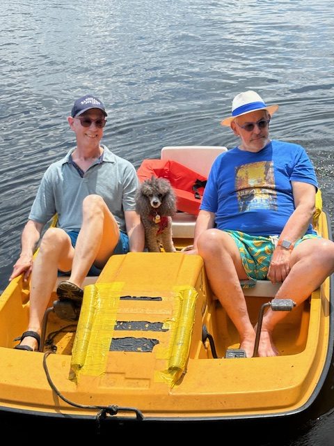 two men and a dog in paddleboat