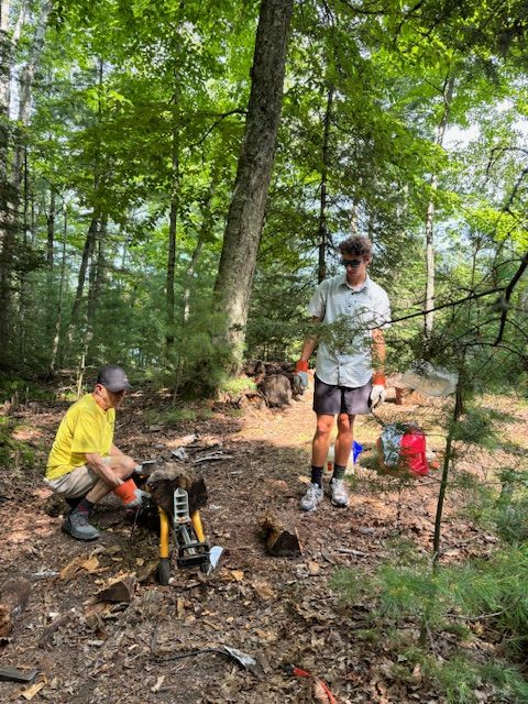 two men watching log splitter in action