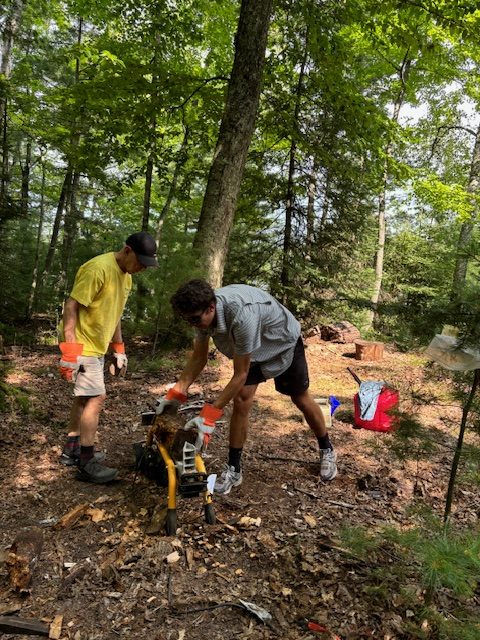 Two men using a log splitter