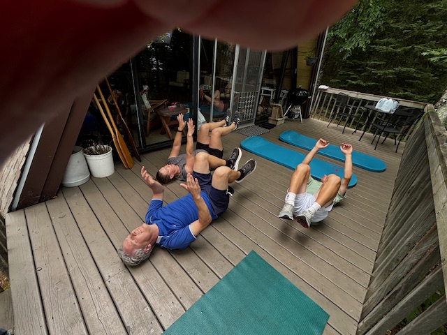 photo of three people on deck doing the dead bug exercise